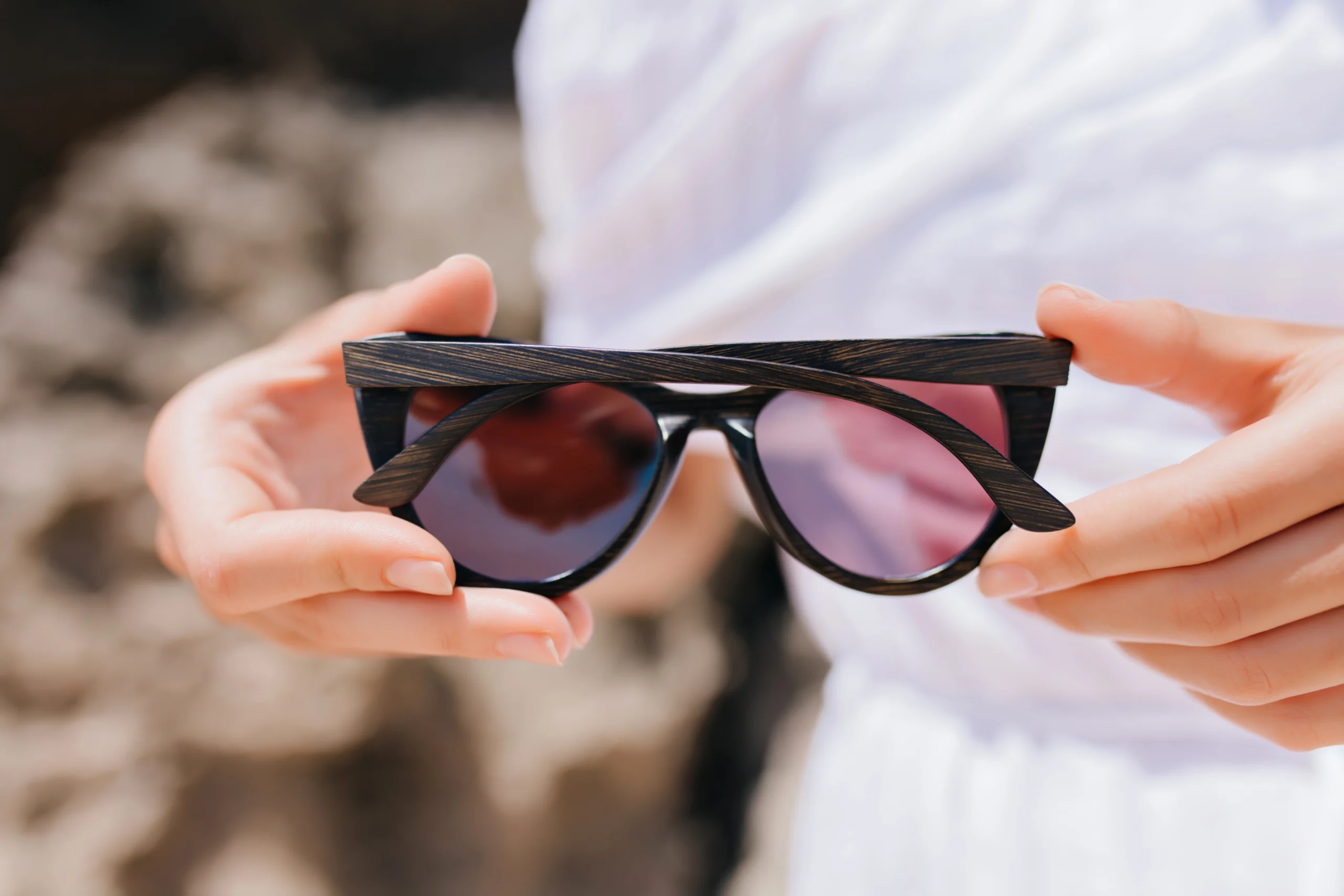 Mujer sosteniendo gafas oscuras