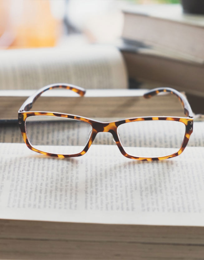 Gafas oftalmicas en estilo carey sobre un libro